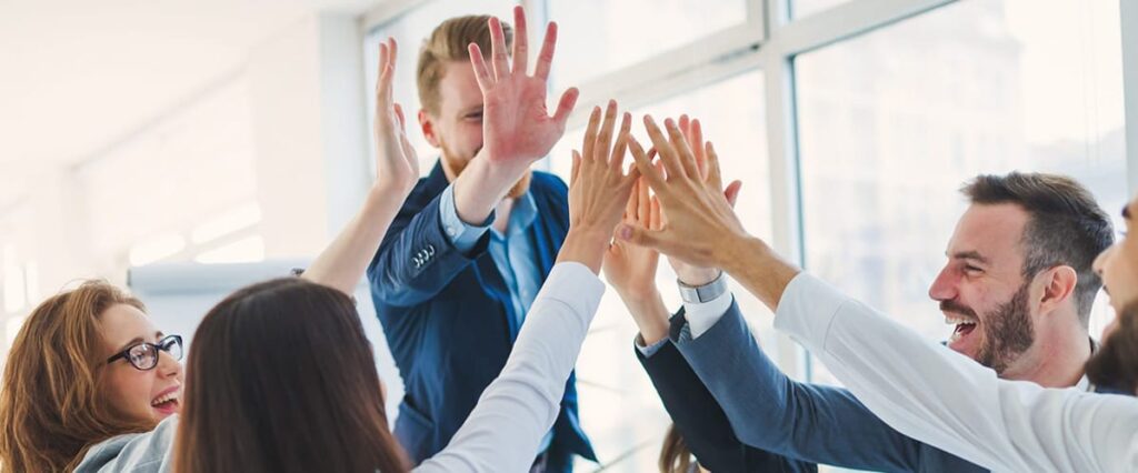 Officemates giving each other high fives